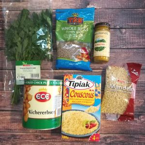 Zutaten für Couscousgericht. Frische Petersilie, Kichererbsen, Couscous von Tipiak, Kreuzkümmel, Kurkuma, gehackte Mandeln