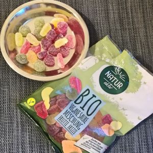 Vegane Saure  Mischung , Frutti Frizzi, von Hofer bzw. Aldi Süd. Verpackung sowie ein Teller mit Fruchtgummis sind abgebildet.